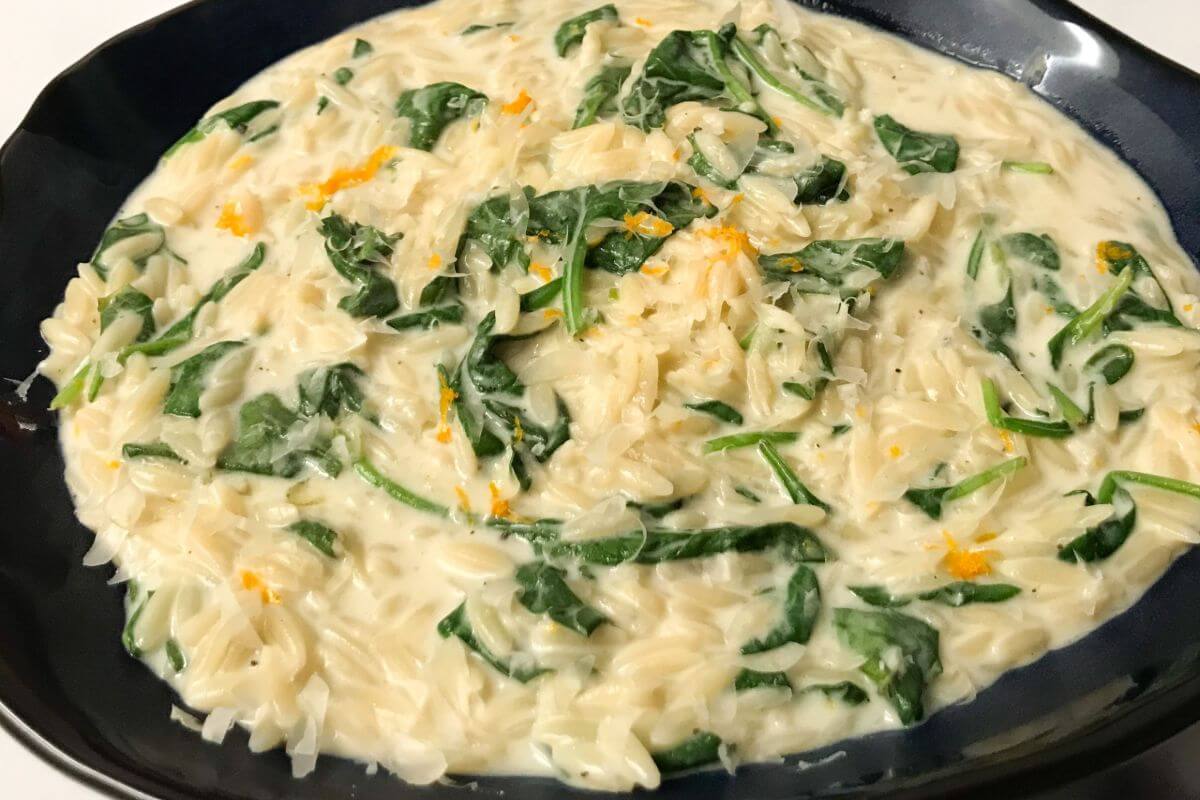 Finished whole wheat orzo orange & spinach in a bowl | mycuratedtastes