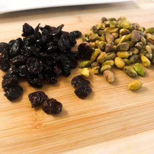 nuts and cherries on a cutting board.