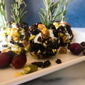 Pistachio cherry goat cheese balls on a platter.