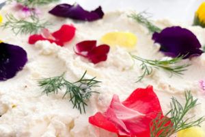 Whipped Feta garnished with fresh flowers and herbs.