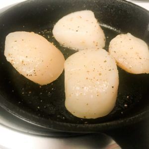 raw scallops in a skillet.