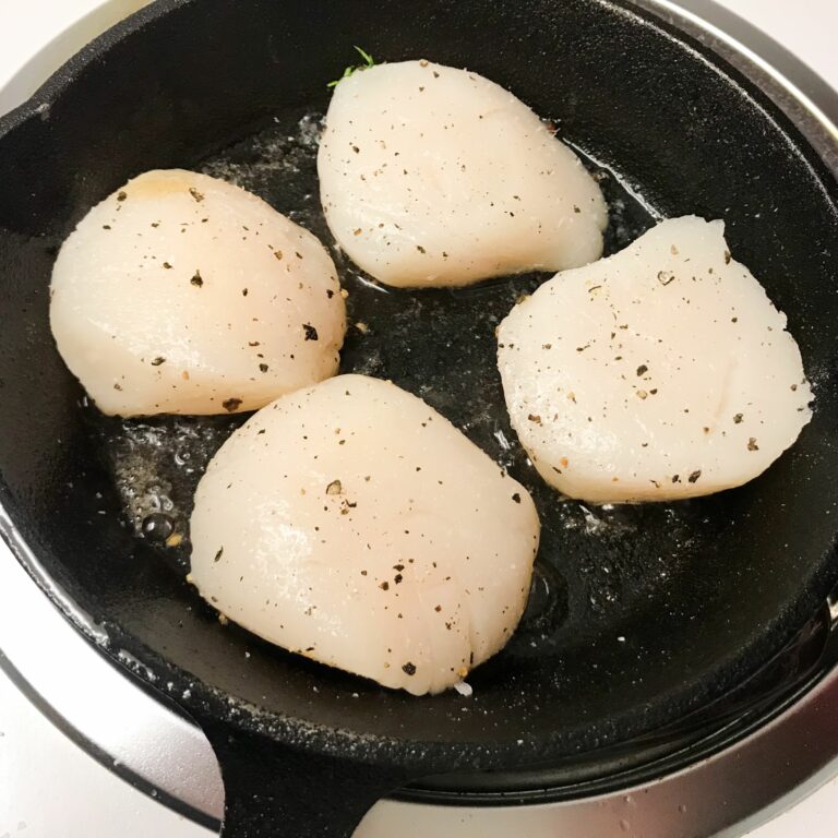 raw scallops in skillet.
