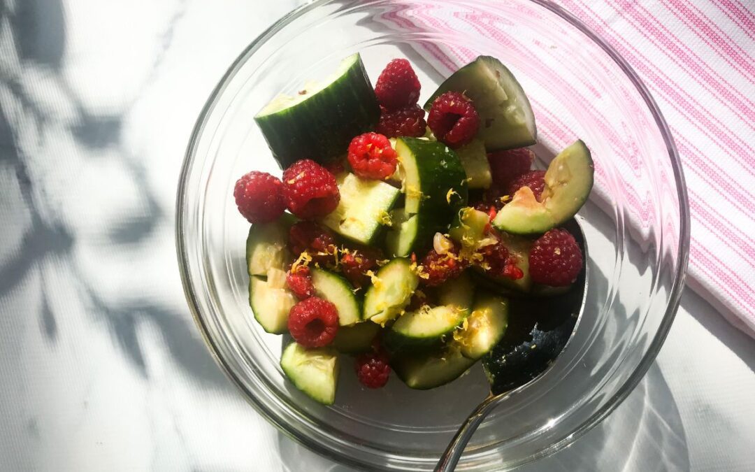 smashed cucumbers and raspberries in a bowl