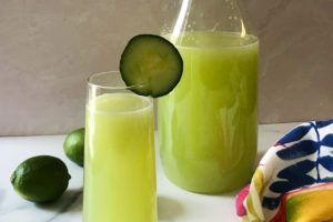 Glass and pitcher of cucumber and lime agua fresca.