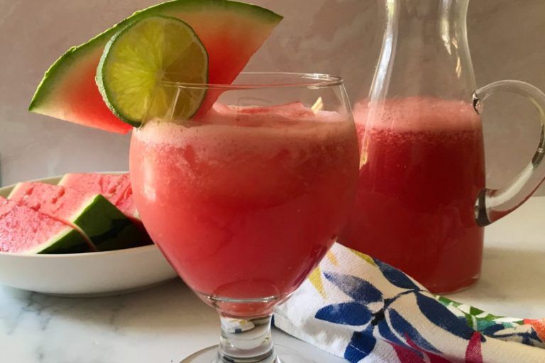 Glass and pitcher of watermelon agua fresca.