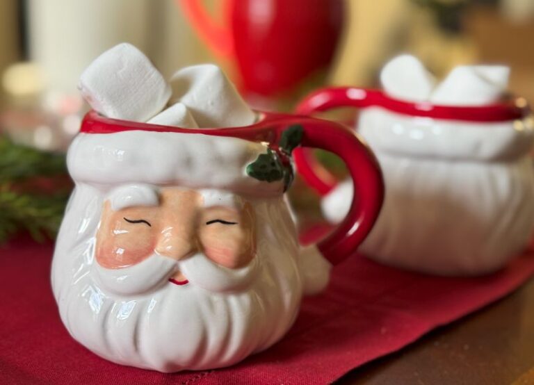 a santa mug filled with hot chocolate and marshmallows.