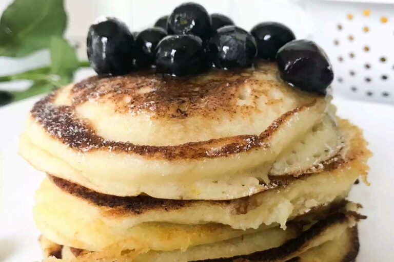 Lemon Ricotta Pancakes for Two topped with blueberries and syrup.