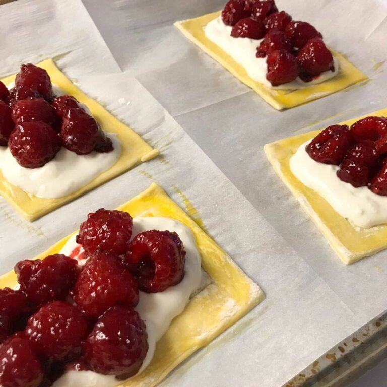 puff pastry topped with filling and glazed raspberries.