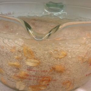 sugar, corn syrup and peanuts bubbling in measuring cup.