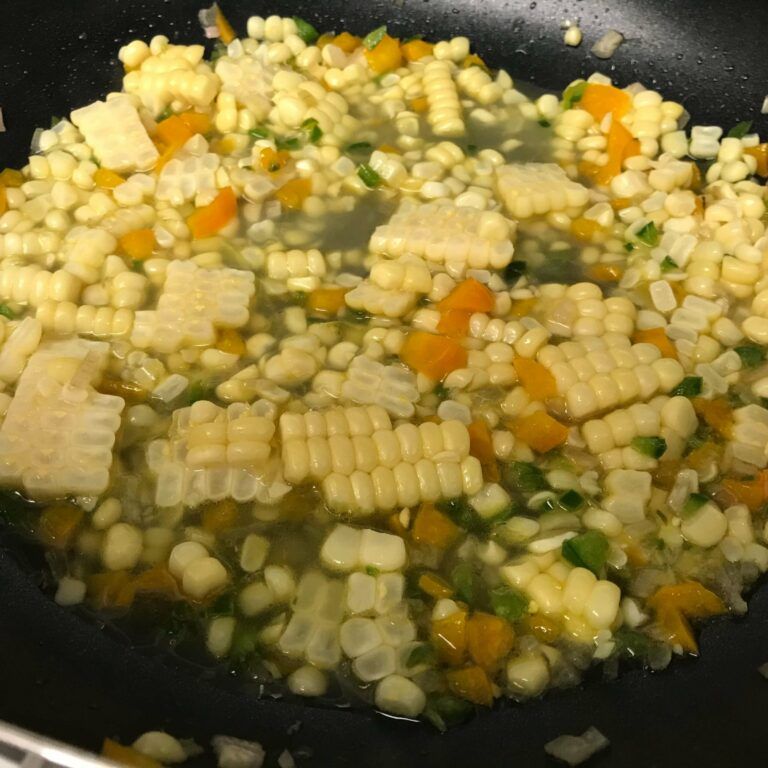 veggies and stock cooking in skillet.