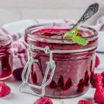 sugar free jarred raspberry jam with a spoon.