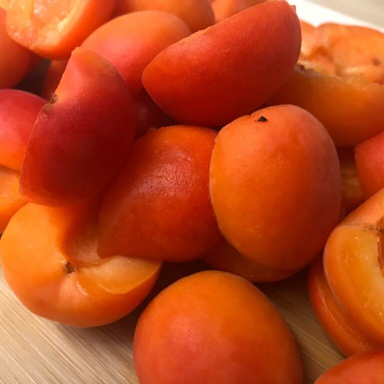 halved fresh apricots on a cutting board
