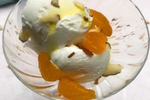 Up close look of ice cream with almonds and mandarin oranges