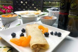 Citrus and Blueberry Blintzes on a plate with blueberries and mandarin sections