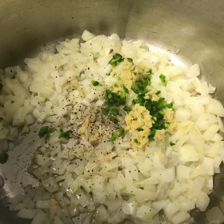 onions and garlic, ginger and jalapeno cooking in a pot