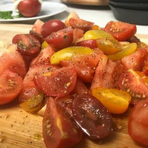 fresh chopped tomatoes on a cutting board with salt and pepper