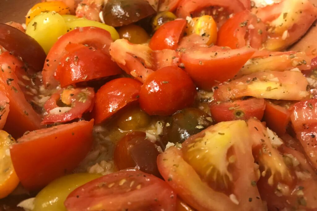 fresh chopped tomatoes in a skillet with oil and garlic