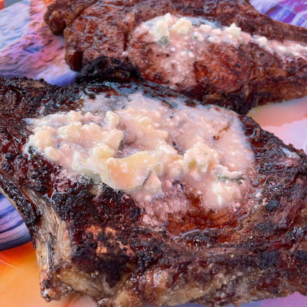 cooked rib eyes with blue cheese butter on top.