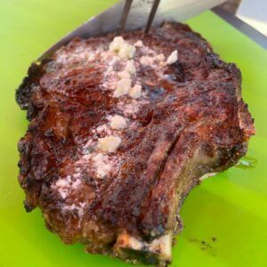 slicing a cooked rib eye steak