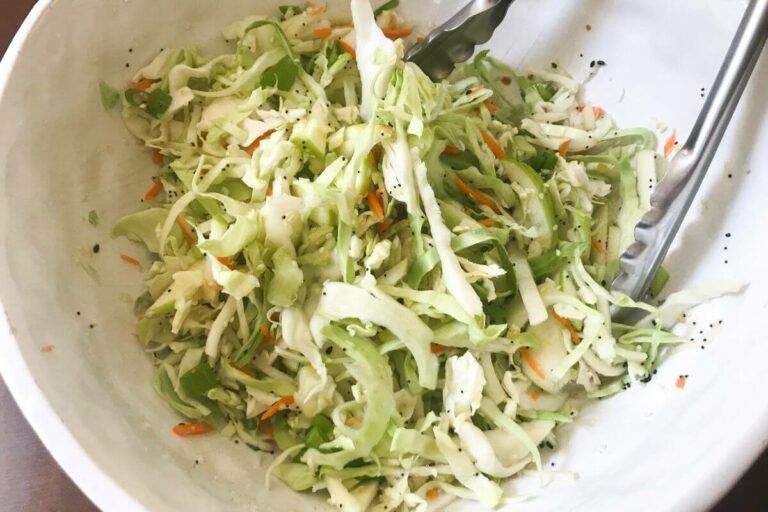 bowl of coleslaw with thongs