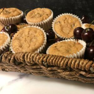 cooked muffins and cherries in a basket