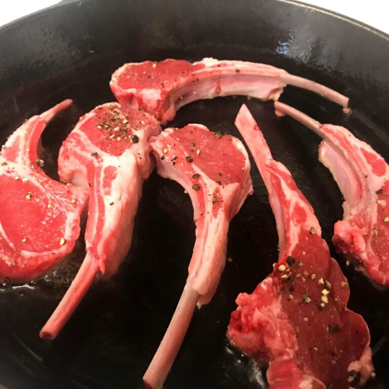 seasoned lamb chops in cast iron skillet
