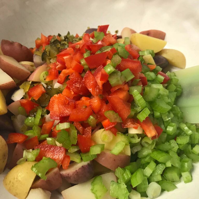 cooked potatoes and chopped veggies in a bowl