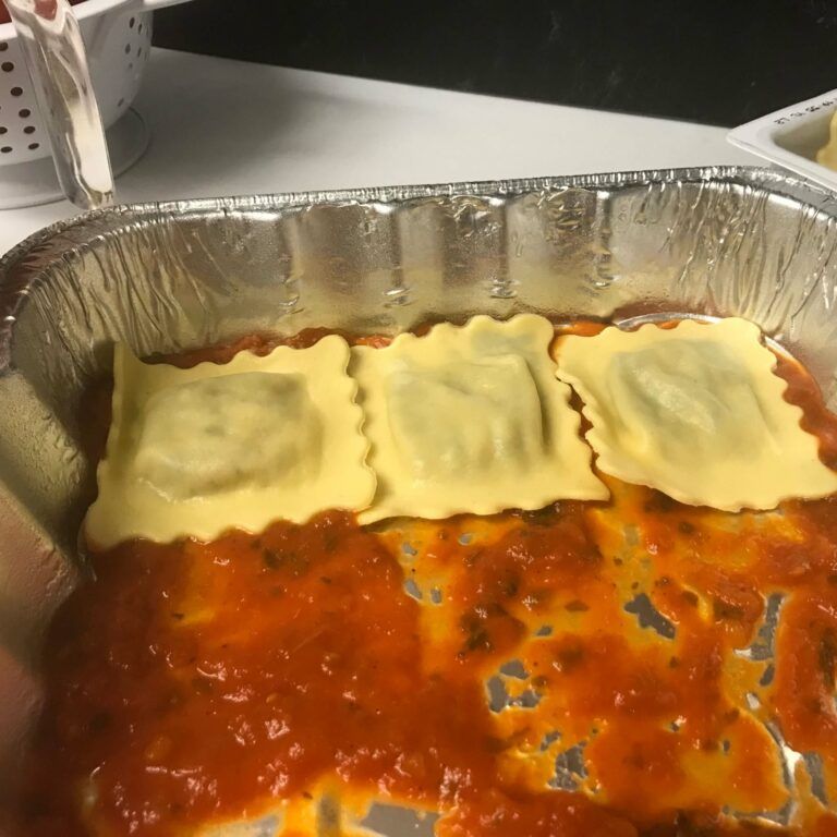 three ravioli on top of sauce in pan