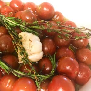 tomatoes, herbs and garlic in baking dish