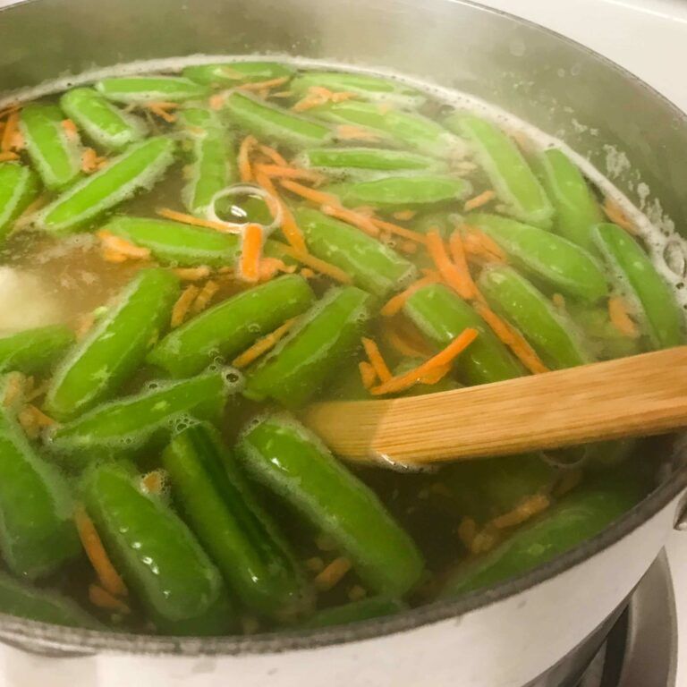 pot of cooking peas carrots and shrimp