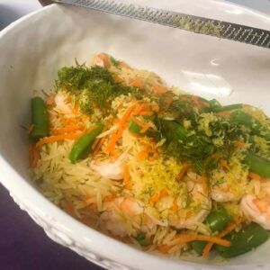 bowl of cooked ingredients with a zester on top of bowl