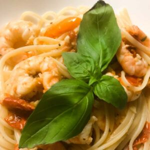 up close photo of basil leaf on top of pasta