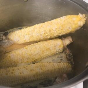 corn cobs in pot with stock