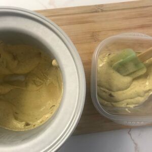 frozen bowl of ice cream and freezer container with some ice cream in it