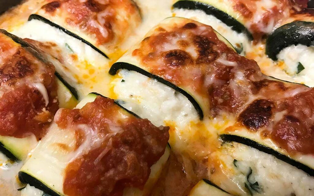 Zucchini lasagne roll ups cooked in a pan