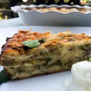 a slice of the zucchini feta pie on a plate with yogurt