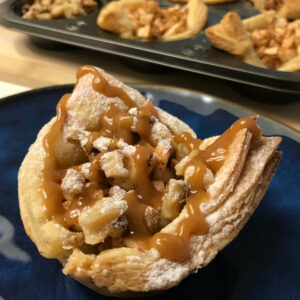 one tartlet with nuts, caramel sauce and powdered sugar.