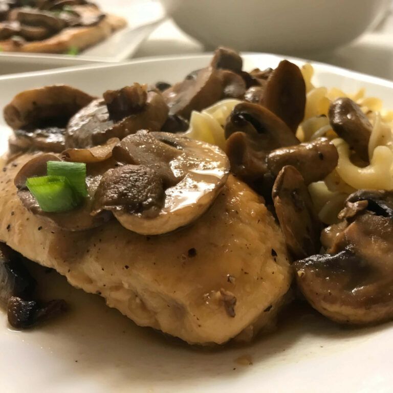 completed chicken marsala with buttered noodles on a plate