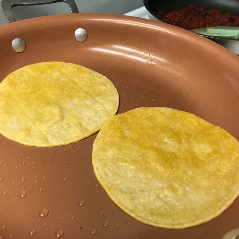 corn tortillas cooking in skillet