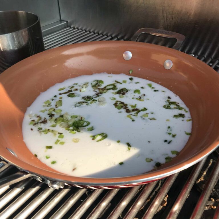 milk and onions in a skillet on the grill