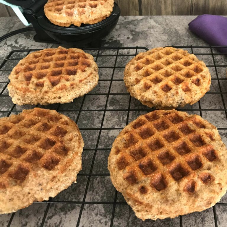 cooked cornmeal waffles on a rack.