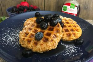 plate of waffles topped with blueberries.