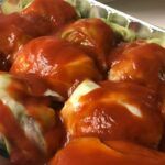 tray of stuffed cabbage covered in tomato sauce