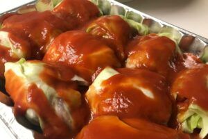 tray of stuffed cabbage covered in tomato sauce