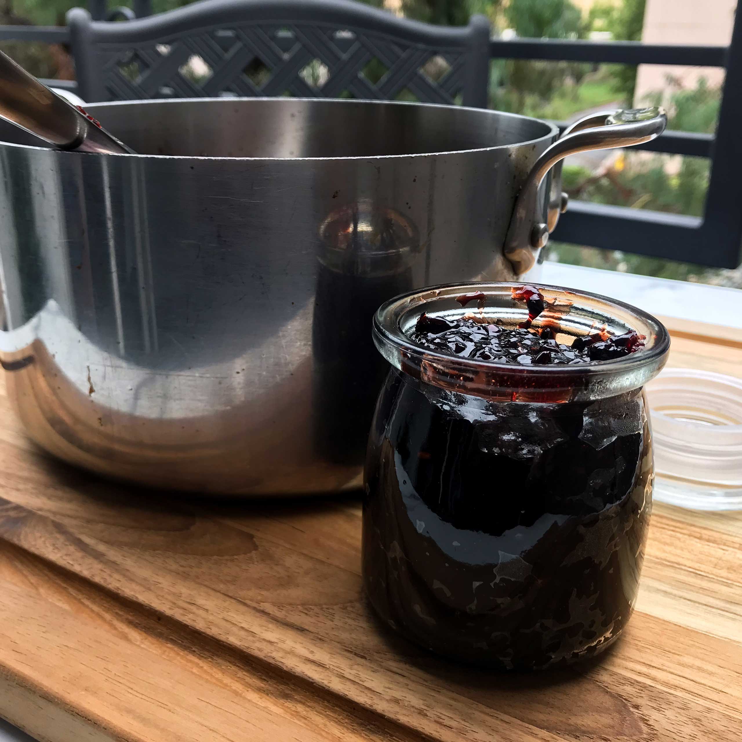 full jar of jam next to pot
