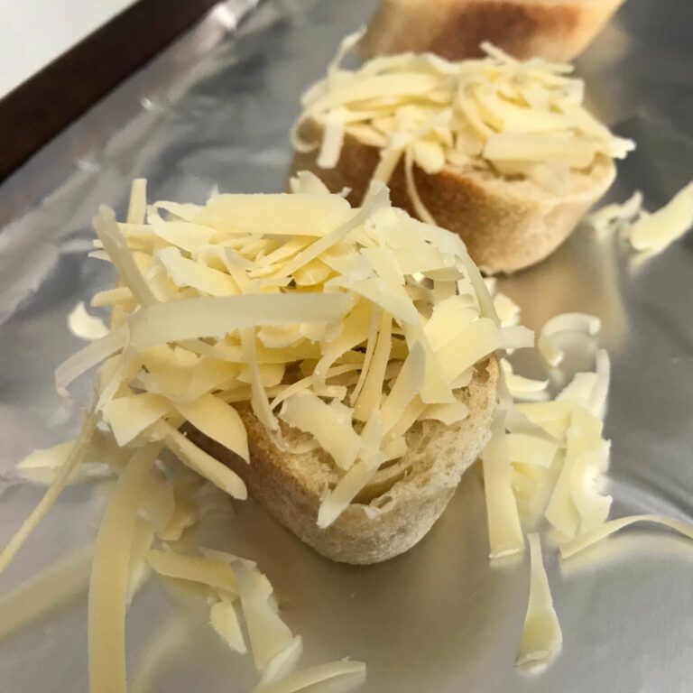 cheese on toasts on baking sheet