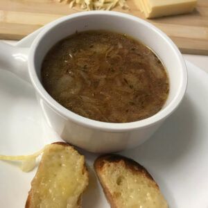 cup of soup with cheese toasts on the side