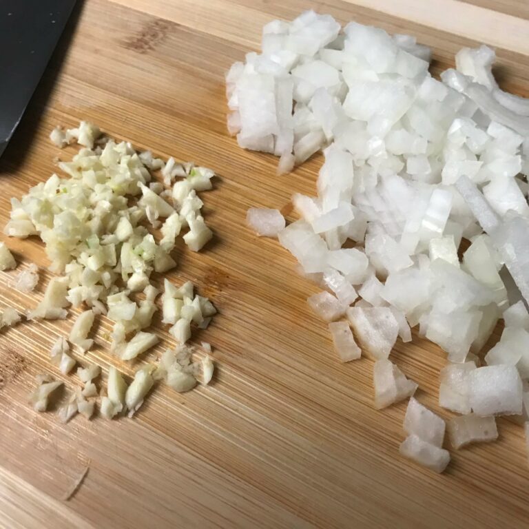 chopped onion and garlic on a cutting board