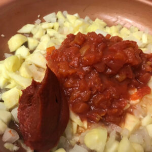 zucchini, onion, garlic, tomato and tomato paste in a skillet