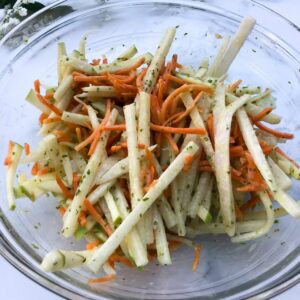 veggies and dressing mixed in a bowl.